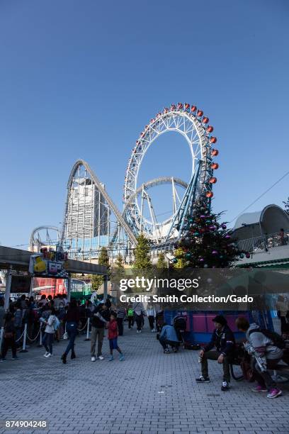 People sit and walk in a large crowd at Tokyo Dome City , an entertainment area in Bunkyo ward, Tokyo, Japan, November 3, 2017.