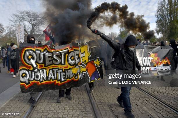 Protester holds a flare in front of a banner reading "what are we waiting for?" during a nationwide protest day against the government's economic and...