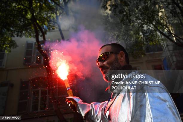 Protester holds a flair as he takes part in a demonstration as part of a nationwide protest day against the government's economic and social reforms,...