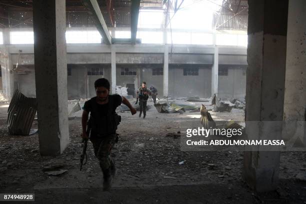 Rebel fighters from the Ahrar al-Sham brigade inspect the interior of a damaged building in the rebel-held besieged town of Harasta, in the Eastern...