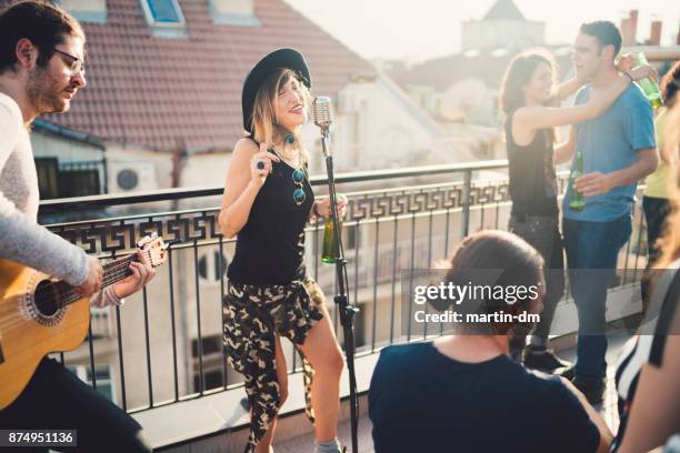 music band performing on rooftop party - martin guitar stock pictures, royalty-free photos & images