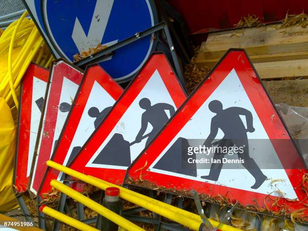 pile of men at work signs - diversion stock pictures, royalty-free photos & images