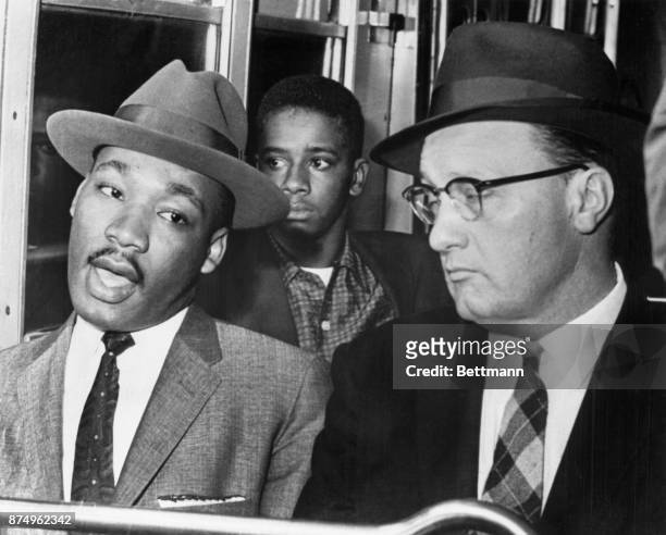 Reverend Martin Luther King, leader of the Montgomery Bus Boycott that started about a year ago, is shown riding a Montgomery Bus up front with the...