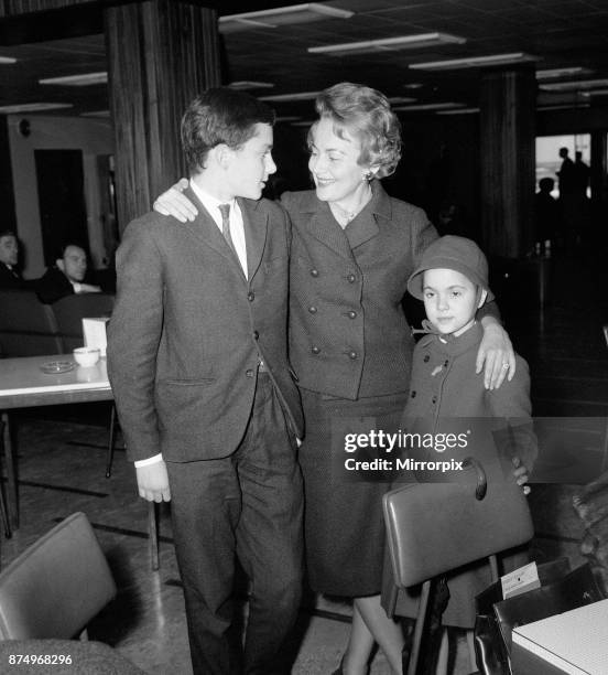 Olivia De Havilland at London Airport with her children Benjamin and Gisele waiting for a flight home to Paris, 15th April 1964.