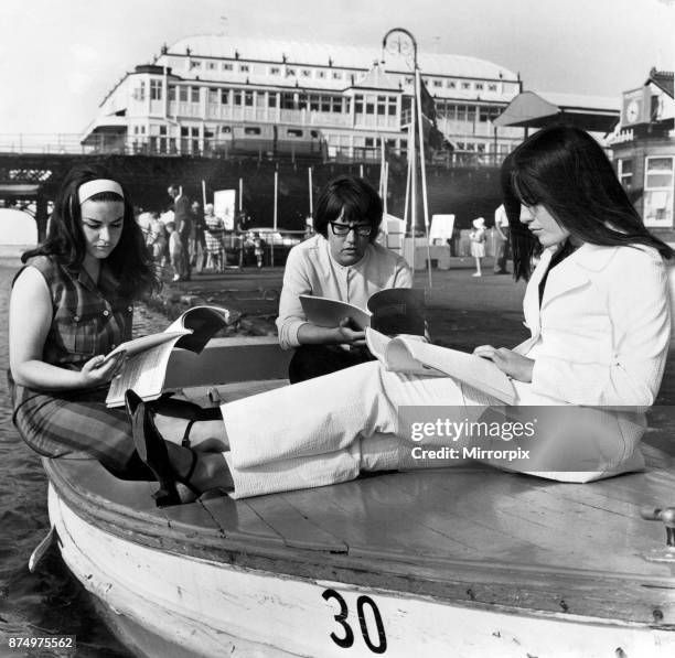 Taking advantage of the warm weather, three of the cast of the Victoria Theatre Company go afloat to scan their scripts Sandra Griffin, Diane...
