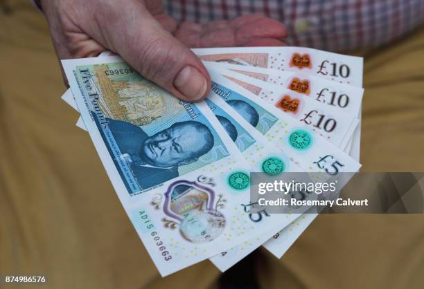newly printed five and ten pound notes held in hand. - ten pound note ストックフォトと画像