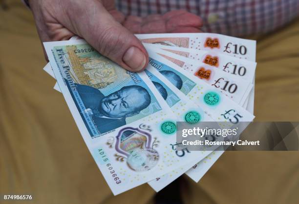 newly printed five and ten pound notes held in hand. - ten pound note stock pictures, royalty-free photos & images