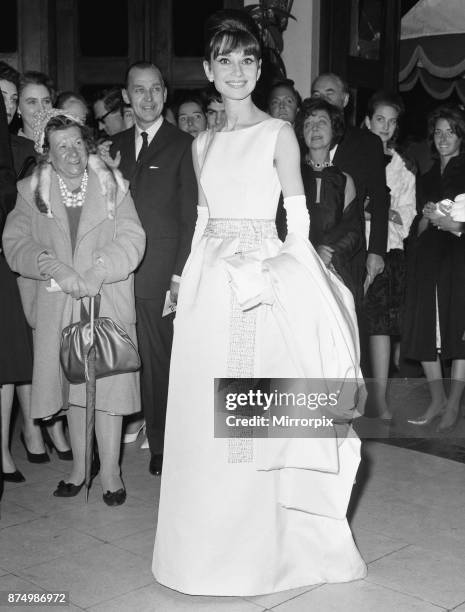 Actress Audrey Hepburn arrives at the London premiere of her latest movie 'Breakfast At Tiffany's' at the Plaza Theatre, watched by an admiring...