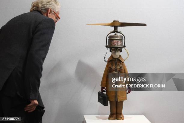 Man stands next to a sculpture entitled "Représentant Champion à Hélice," by French artist Stephane Halleux, during a private preview of the "ST-ART"...