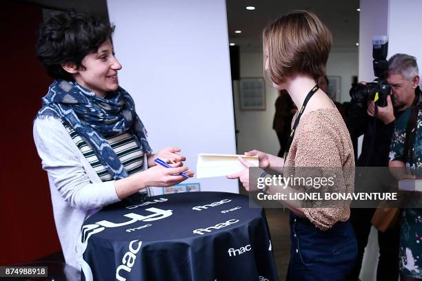 French writer Alice Zeniter signs her book after being awarded the Prix Goncourt des Lyceens for her novel "The Art of Losing" on November 16 in...