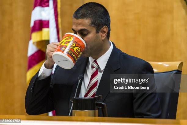 Ajit Pai, chairman of the Federal Communications Commission , drinks from an oversized coffee mug during an open meeting in Washington, D.C., U.S.,...