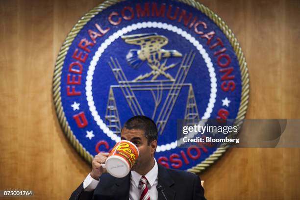 Ajit Pai, chairman of the Federal Communications Commission , drinks from an oversized coffee mug during an open meeting in Washington, D.C., U.S.,...