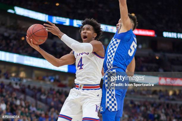 Kansas Jayhawks guard Devonte' Graham battles with Kentucky Wildcats forward Kevin Knox during the State Farm Classic Champions Classic game between...