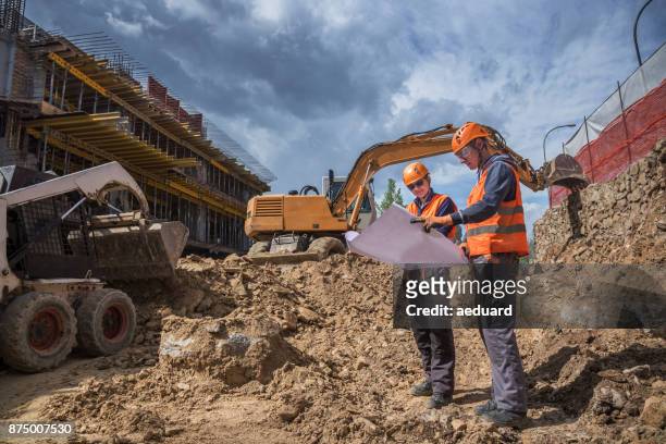 engineers verifying blueprints - construction equipment stock pictures, royalty-free photos & images