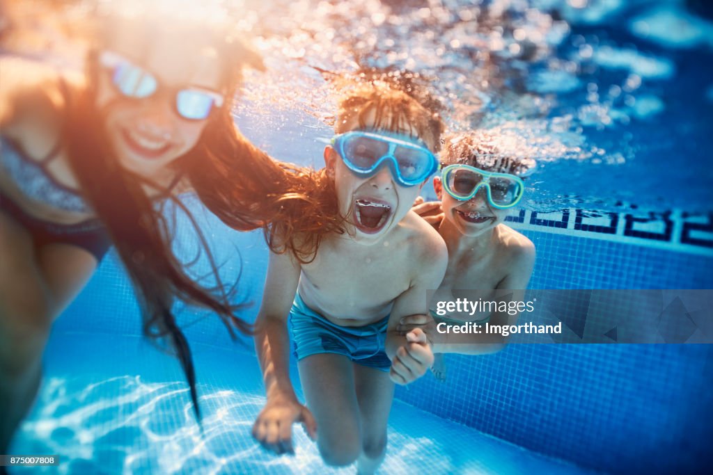 Happy kids playing underwater