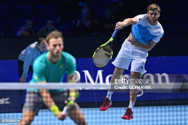Player Ryan Harrison serves as New Zealand's Michael Venus stands ready against Netherlands' Jean-Julien Rojer and Romania's Horia Tecau during their...