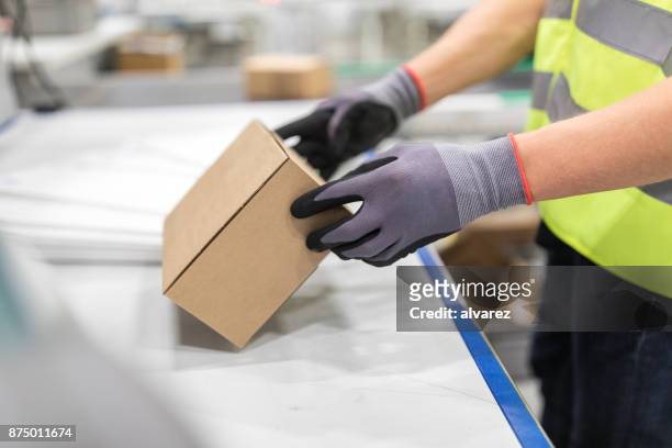 arbeiter überprüfen pakets vom förderband in lager - boxes conveyor belt stock-fotos und bilder