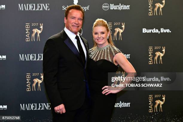 Actor and founder of the R20 climate action group Arnold Schwarzenegger and his partner Heather Milligan pose on the red carpet upon their arrival...