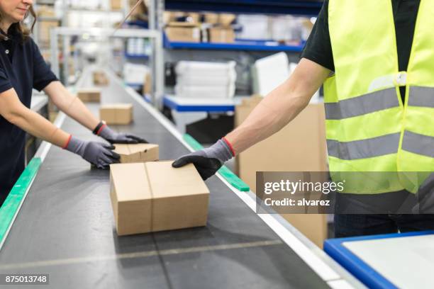 werknemers werken op transportband in verpakking plant - packing boxes stockfoto's en -beelden