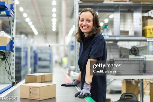 mujer que trabaja en almacén de distribución de grandes - production line fotografías e imágenes de stock