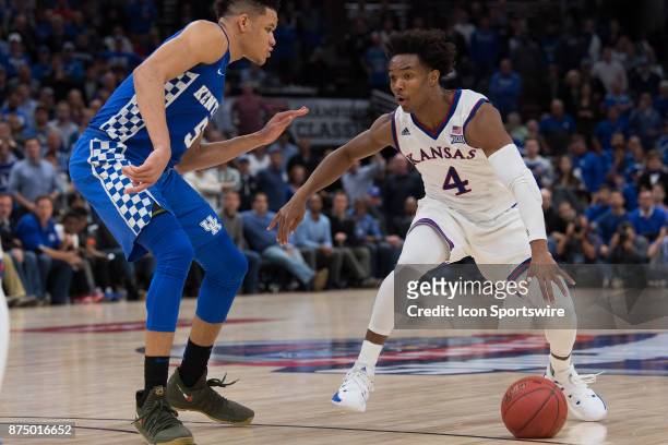 Kansas Jayhawks guard Devonte Graham dribbles on the perimeter against Kentucky Wildcats forward Kevin Knox during the State Farm Champions Classic...