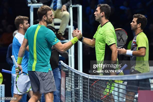 Player Ryan Harrison and New Zealand's Michael Venus shakes hands with Netherlands' Jean-Julien Rojer and Romania's Horia Tecau after winning their...