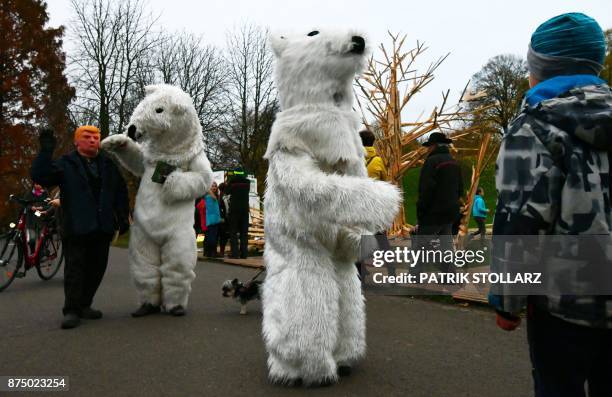Picture taken on November 16, 2017 shows people dressed up in polar bear costumes and a man with a mask of US president Donald Trump during a...