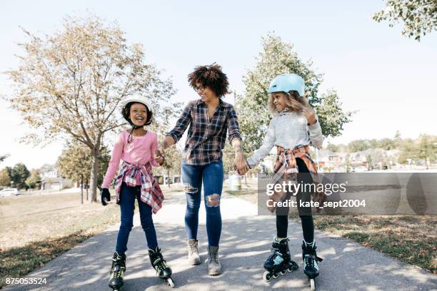 happy siblings on rollerblades - roller skating outside stock pictures, royalty-free photos & images