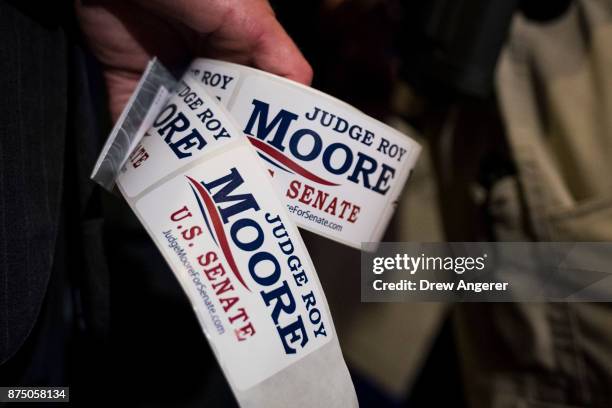Supporter of Republican candidate for U.S. Senate Judge Roy Moore holds campaign stickers during a news conference with supporters and faith leaders,...