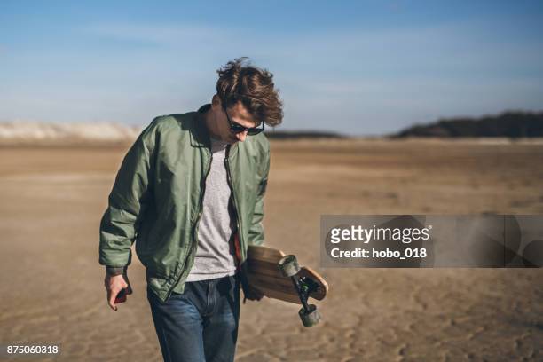 skater en la playa - jacket fotografías e imágenes de stock