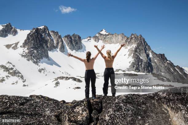 topless women on a mountain peak - ski pants stockfoto's en -beelden