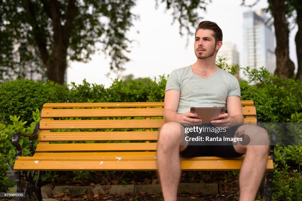 Young handsome man relaxing at Lumpini Park in the city of Bangkok Thailand