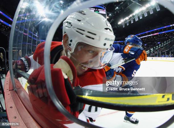 Johnny Boychuk of the New York Islanders hits Jordan Staal of the Carolina Hurricanes into the boards during the first period at the Barclays Center...