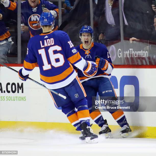 Mathew Barzal of the New York Islanders celebrates his goal at 16:21 of the first period against the Carolina Hurricanes and is joined by Andrew Ladd...