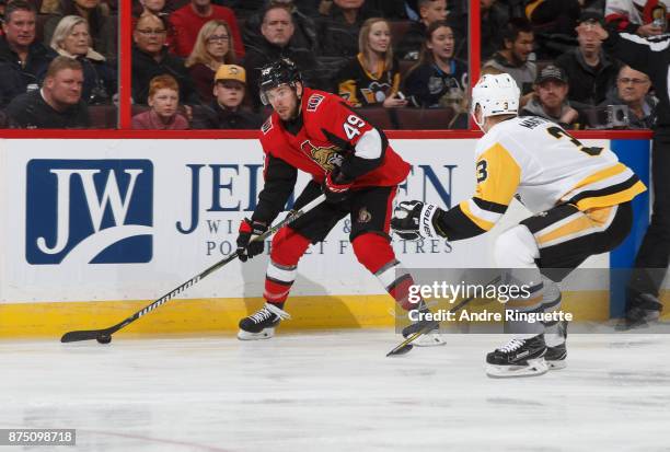 Christopher DiDomenico of the Ottawa Senators stickhandles the puck against Olli Maatta of the Pittsburgh Penguins at Canadian Tire Centre on...