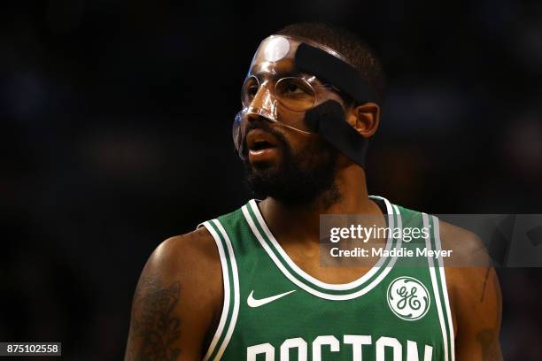 Kyrie Irving of the Boston Celtics, wearing a mask due to a facial fracture, looks on during the first quarter against the Golden State Warriors at...