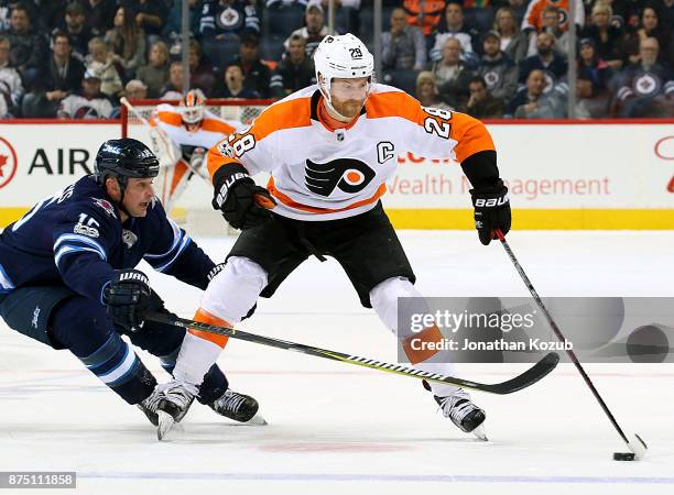 Claude Giroux of the Philadelphia Flyers plays the puck down the ice as Matt Hendricks of the Winnipeg Jets gives chase during first period action at...