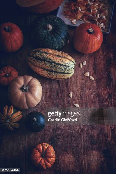 variation of pumpkins on rustic background - hokaido pumpkin stock pictures, royalty-free photos & images