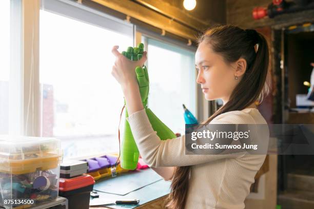 engineer examining robotics in workshop - 3d printer female stock-fotos und bilder