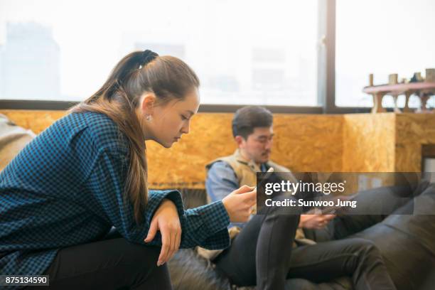 engineers focused on smartphone in workshop - bean bag stock pictures, royalty-free photos & images