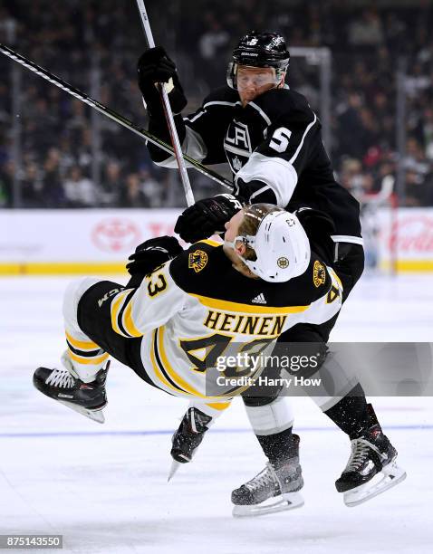 Christian Folin of the Los Angeles Kings checks Danton Heinen of the Boston Bruins during the second period at Staples Center on November 16, 2017 in...