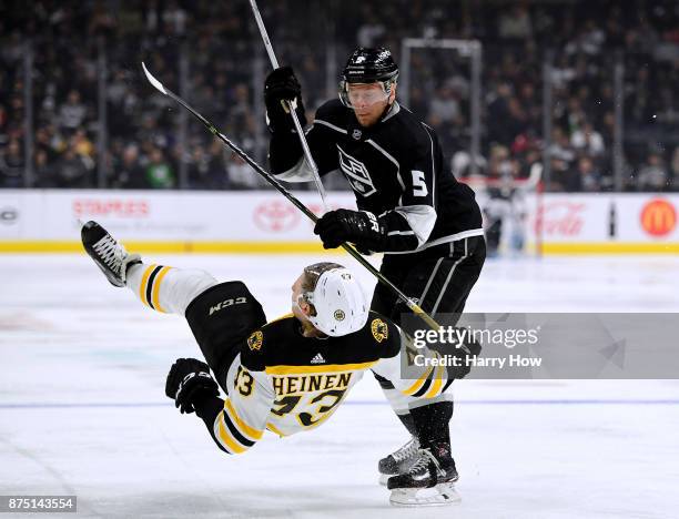 Christian Folin of the Los Angeles Kings checks Danton Heinen of the Boston Bruins during the second period at Staples Center on November 16, 2017 in...