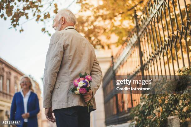 man met een boeket - hands behind back stockfoto's en -beelden