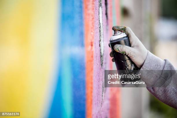graffiti artist drawing graffiti on wall - spray cleaner stock pictures, royalty-free photos & images