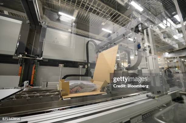 The Neopost SA CVP-500 automated packing system packs a blanket in a cardboard box during a demonstration at the Yamato Holdings Co. Atsugi Gateway...