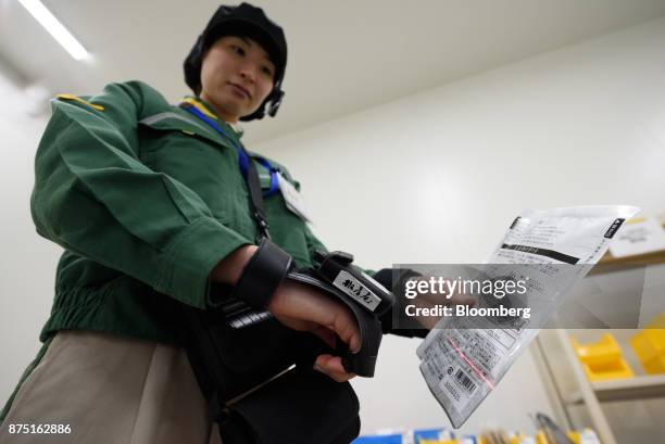 Yamato Logistics Co. Employee scans a product during a demonstration of inspection technologies at the Yamato Holdings Co. Atsugi Gateway...