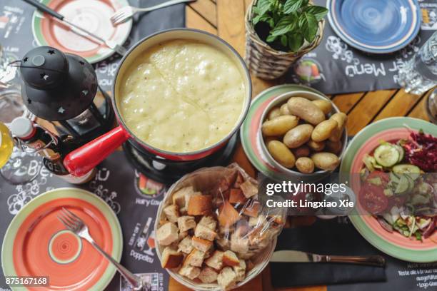 classic swiss cheese fondue with breads and potatoes, switzerland - hot pots stock-fotos und bilder