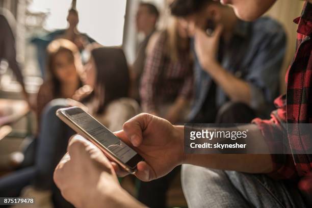 nahaufnahme von unkenntlich student mit handy bei einer pause im klassenzimmer. - people chatting stock-fotos und bilder