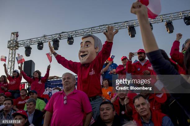 Supporter wearing a mask in the likeness of presidential candidate Sebastian Pinera cheers during a campaign rally for Pinera in Santiago, Chile, on...