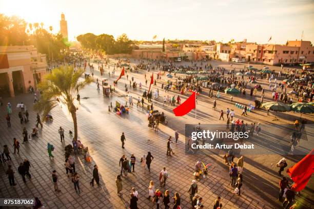 beautiful sunset in the jemaa el fna square in the city of marrakech with bustle activity, street food market lights and colorful sky, picture taken during travel vacations in morocco. - marokko marrakesh stock-fotos und bilder